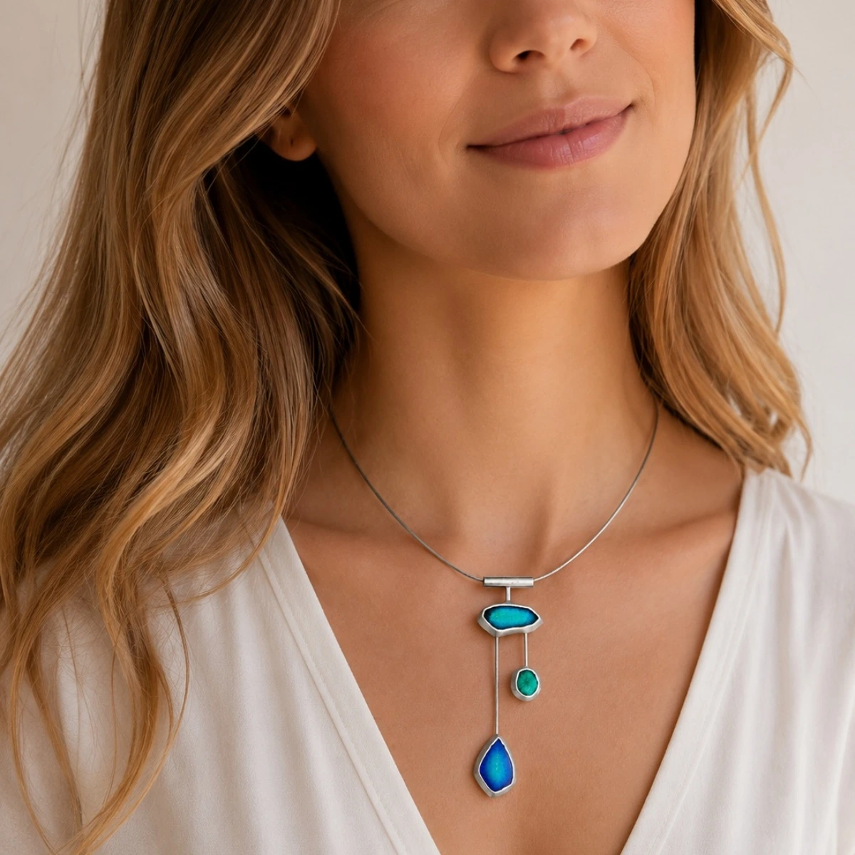 halsreif-silber-925-meerglas-tanz-der-wellen-model Dreistufiger asymmetrischer Anhänger der Halskette Silber 925 Meerglas Tanz der Wellen mit blau-grüner Emaille an einem grauen Edelstahlreif; Collier mit Meerglas in Blau Grün