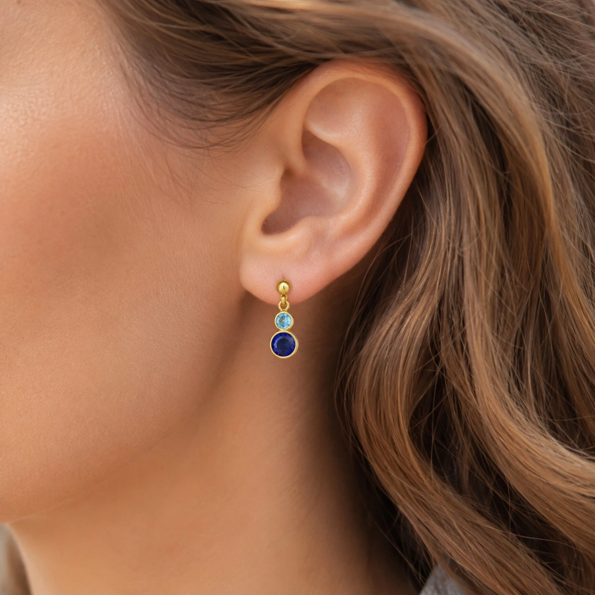 ohrstecker-gold-585-meeresduett-zirkonia-ohr Elegante Gold Ohrstecker mit zwei verschiedenfarbigen Zirkonia in Hellblau und Dunkelblau.