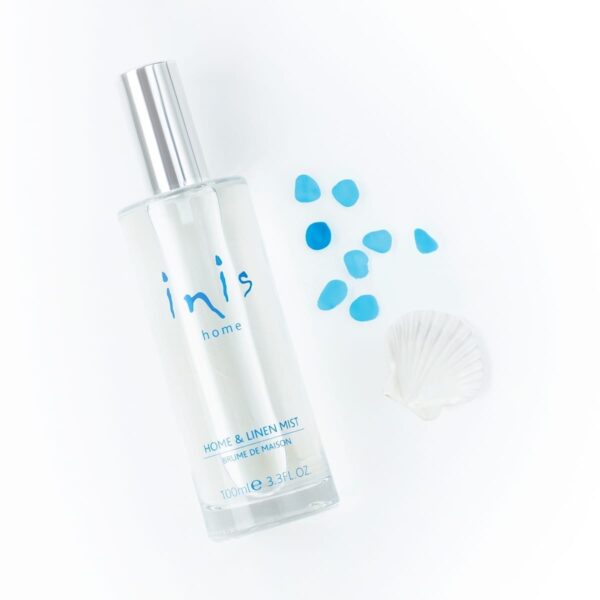 Inis Wäschespray 100 ml mit silberner Kappe, Muschel und blauen Dekosteinen auf weißem Hintergrund