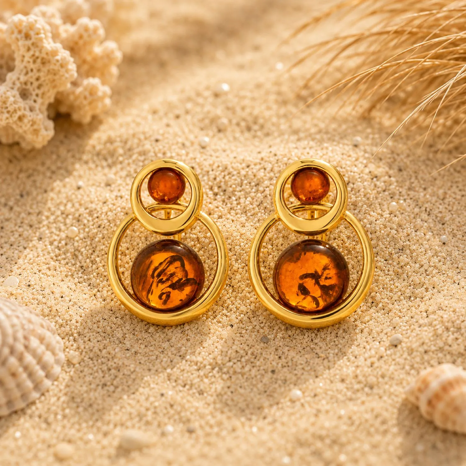 bernstein-ohrstecker-gold-375-goldene-duenen-cognac-sand Bernstein Ohrstecker Gold 375 „Goldene Dünen“ Cognac mit zwei Cognac Bernsteinsteinen und runder Goldform; Bernstein Ohrringe mit maritimem Motiv; eleganter Schmuck mit Ostseebernstein